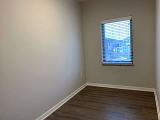 A room with a window and wooden flooring.