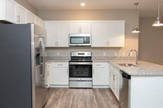A kitchen with white cabinets and a granite countertop.