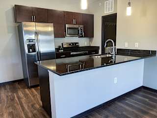 A kitchen with a refrigerator, microwave, and stove.