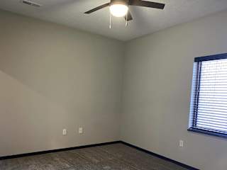 carpeted master bedroom with large window