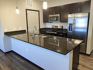 Kitchen in the espresso finish with dark granite counter tops