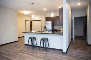 A kitchen with a bar stool and a counter.