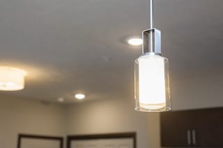 A modern pendant light is hanging from the ceiling in a room.
