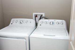 Two white front loading washing machines in a laundry room.