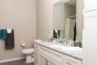A bathroom with a toilet, sink, and mirror.