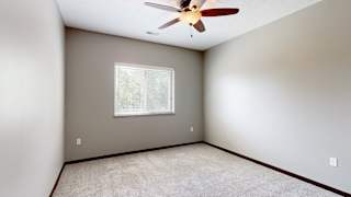 a bedroom with a ceiling fan and a window