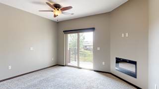 a living room with a ceiling fan and sliding door to the balcony