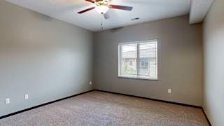 a bedroom with a ceiling fan and a window