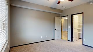 a bedroom with a ceiling fan and a door to walk in closet
