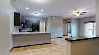 an open living room and kitchen area with a ceiling fan