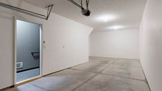 spacious tandem garage with a white walls and concrete floor