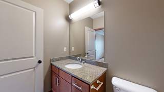 the primary bathroom with a light granite vanity and overhead lighting