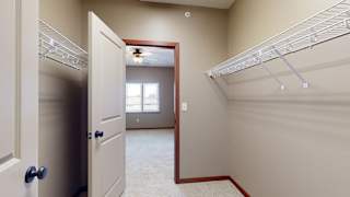a walk through closet with two hanging shelves