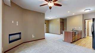 a living room with a fireplace and a ceiling fan