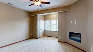 a living room with a ceiling fan and a fireplace