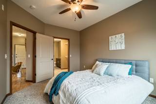 A bedroom with a large bed and a ceiling fan.