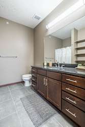 A bathroom with a toilet, sink, and mirror.