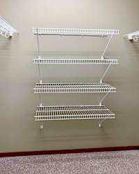 A walk-in closet with several built-in shelves and hanging space.