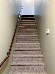 A carpeted staircase leading up to the living area, with a wooden handrail.