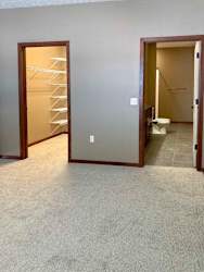 A bedroom with a walk-in closet and attached bathroom.