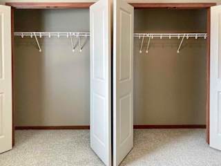 A bedroom with two side-by-side closets.