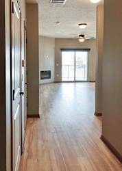 A hallway with closets leading to an open living room.