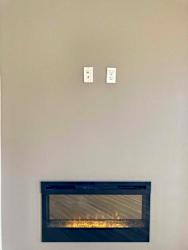 An electric fireplace with two outlets to mount a tv above.