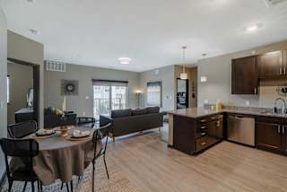 A modern kitchen with dark wood cabinets and a dining table set for two