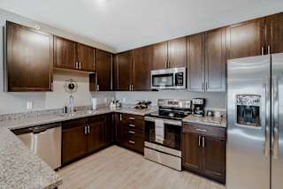 A modern kitchen with brown cabinets and stainless steel appliances