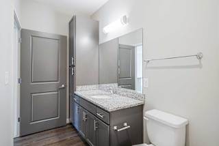 a bathroom with a granite countertop sink and storage
