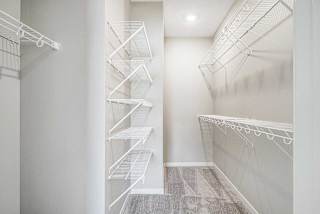a walk in closet with built-in wire shelves and hanging space