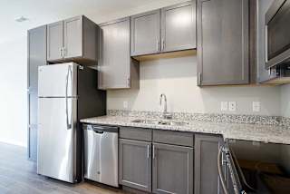 a kitchen with stainless steel appliances and grey cabinets