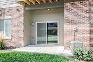 the sliding glass door of a first floor Lilac apartment with a patio space