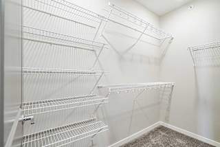 a walk-in closet with built in wire shelving