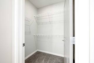 a walk-in closet with built-in shelving on two walls