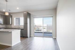 an open kitchen and dining room with a door to a balcony