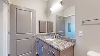 a bathroom with a large vanity sink with granite countertop and a mirror