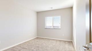 a bedroom with a large window and carpeting
