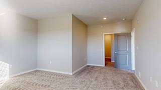 an L-shaped bedroom with an attached bathroom and walk-in closet