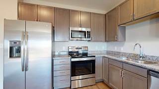 a kitchen with stainless steel appliances and grey wooden cabinets