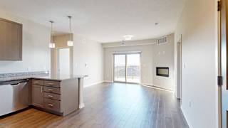 an open living room with a fireplace next to a kitchen with a peninsula countertop