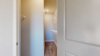 a long walk-in closet with built-in shelving for extra storage space