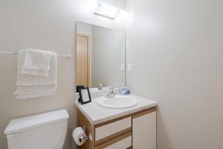 a bathroom with a toilet, sink, and a mirror