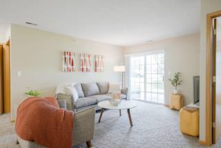 Furnished living room with a couch and a coffee table and orange accents