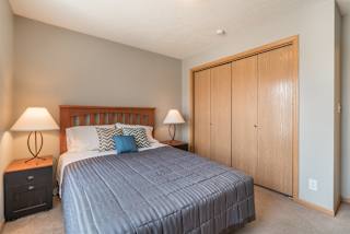 room with bed, 2 nightstands with lamps, and bifold closet doors