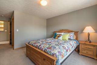 room with bed and one nightstand with lit lamp