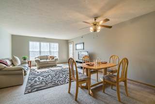 a living room with a dining room table and a ceiling fan