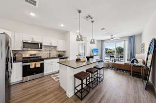 A modern kitchen with a large island and stainless steel appliances.at Fora Apartments, Nevada