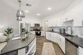A modern kitchen with a large island and stainless steel appliances.at Fora Apartments, Las Vegas, NV 89183