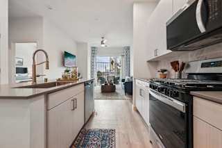 A modern kitchen with a black stove top oven.at Coya Apartments, Las Vegas